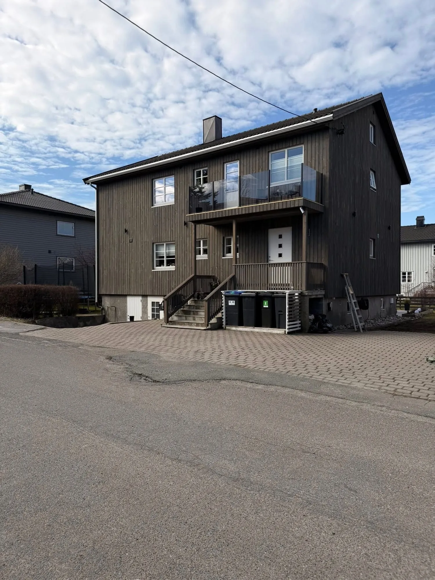 Huset etter, med ny kledning, nytt inngangsparti og glassrekkverk
